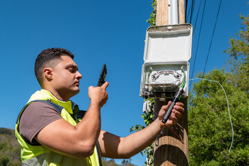 Especialista de telecomunicações em reparos numa caixa de distribuição de fibra ótica