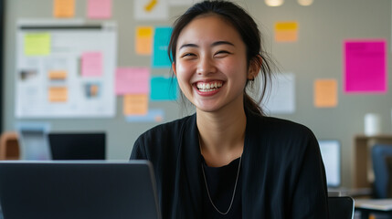 Employee receiving good news via email smiling in front of laptop