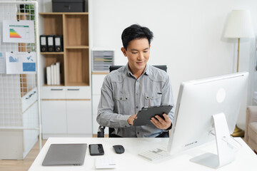 Mature male entrepreneur thinking in office, working online with laptop and documents. small...