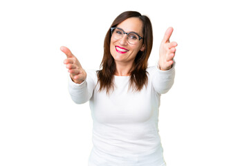 Middle age woman over isolated chroma key background presenting and inviting to come with hand