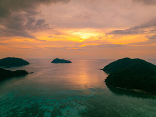 Aerial hyper lapse view of serene sunset over a tropical coastline at Mai Ngam Beach, Surin...