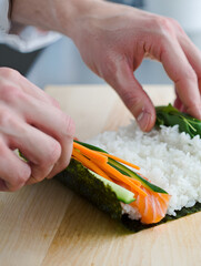 Chef's hands preparing sushi