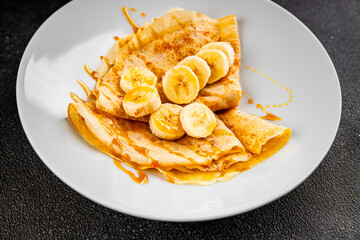 Crepes banana syrup pancakes breakfast dish dessert organic product fresh tasty gourmet food background on the table rustic food top view copy space