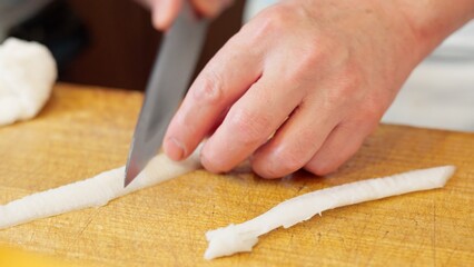 ヒラメのエンガワを切る和食の職人