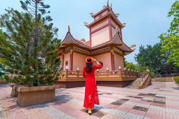 Asian female tourists in ao dai dress visit President Ho Chi Minh's memorial at Ban Na Chok, Nakhon Phanom Province, Thailand.