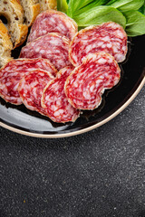 Dry-cured sausage salami appetizer dish fresh delicious gourmet food background on the table rustic food top view copy space