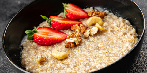 Oatmeal porridge strawberrie nuts healthy breakfast appetizer dish fresh gourmet food background on the table rustic food top view copy space 