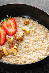 Oatmeal porridge strawberrie nuts healthy breakfast appetizer dish fresh gourmet food background on the table rustic food top view copy space 