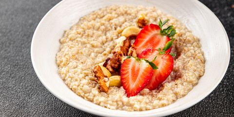 Oatmeal porridge strawberrie nuts healthy breakfast appetizer dish fresh gourmet food background on the table rustic food top view copy space 