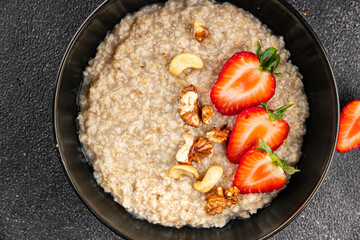 Oatmeal porridge strawberrie nuts healthy breakfast appetizer dish fresh gourmet food background on the table rustic food top view copy space 