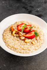 Oatmeal porridge strawberrie nuts healthy breakfast appetizer dish fresh gourmet food background on the table rustic food top view copy space 