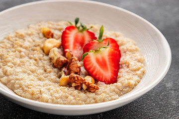 Oatmeal porridge strawberrie nuts healthy breakfast appetizer dish fresh gourmet food background on the table rustic food top view copy space 