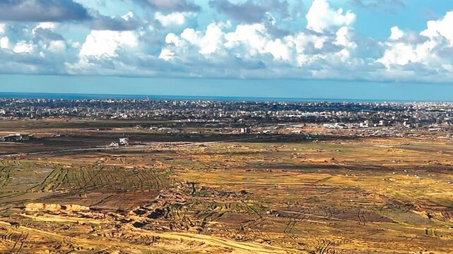 Stunning aerial view over the city of Rafah, capturing a densely populated urban landscape near the desert and borderlines. Shot with a drone in natural daylight, this image highlights the complex 
