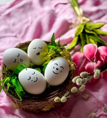 Easter eggs in a wicker basket surrounded by a bouquet of flowers and pussy willow