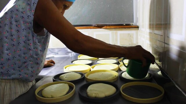 An elderly colombian woman serving delicious Quesillo in circular molds at a restaurant in Yaguar&aacute;, Huila, Colombia. Artisanal food concept
