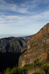 Fototapeta premium A stunning view of the mountain peaks along the Pico do Arieiro to Pico Ruivo trail in Madeira, with clear skies highlighting the rugged terrain.