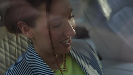 girl in car using smartphone, looking at phone, girl smiling