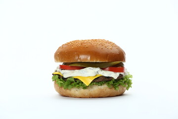 A classic hamburger with a sesame seed bun, beef patty, cheese, lettuce, tomatoes, and pickles , isolated in white
