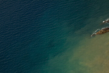 Obraz premium The golden sand smoothly transitions into the deep blue ocean, creating a serene and harmonious contrast. 