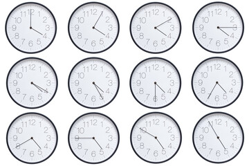  A set of twelve round wall clocks with dark brown frames and white faces showing 5-minute time...