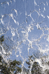 A close-up view of falling water creating intricate patterns as it cascades down. 