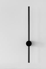 Modern black elegant lamps are on the green wall.