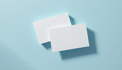 Two blank white cards floating on a light blue background, ideal for business card or credit card mockups
