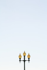  A solitary street light stands tall under the midday sun, casting a long shadow on the pavement. The simplicity of the scene captures the tranquility of Funchal's daytime streets.