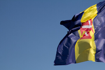 The Funchal flag flutters gracefully in the breeze, its colors vivid against the backdrop of the...
