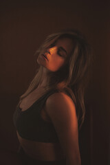 Fototapeta premium Sensual Portrait of Woman in Dramatic Sunset Lighting and Dark Tones
