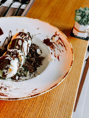 Syrniki topped with Dubai chocolate and almonds served on a stylish wooden table