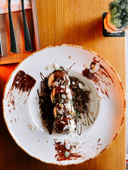 Delicious syrniki served with rich Dubai chocolate and topped with nuts on a wooden table