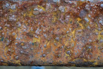 Rusty Metal Surface Showcasing a Rich Texture With Various Colors and Patterns Against a Blurred...