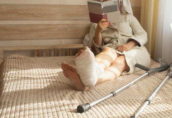 A woman is sitting in a room with a leg injury. bandaged in a cast