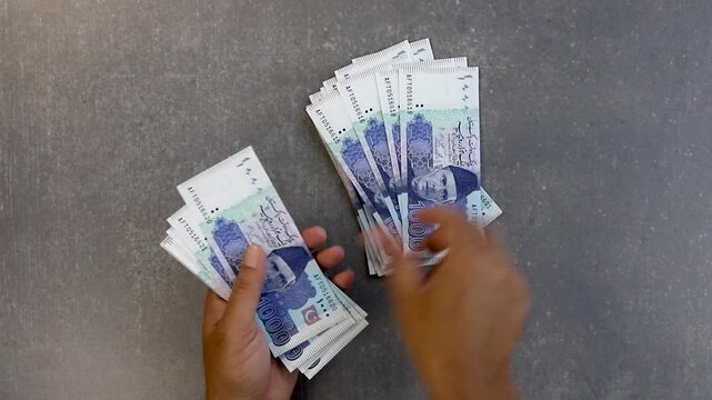 Man counting Pakistan 1000 rupees notes. Shopping concept.