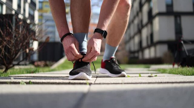 Tying running shoes before workout closeup fitness routine moment outdoor training prep active lifestyle motivation health and self-discipline vibe