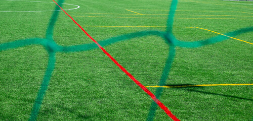 football field with natural grass seen through the net