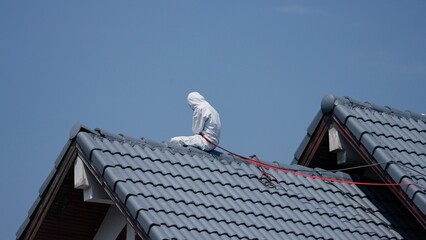 Professional painter on roof   Working at heights is dangerous.