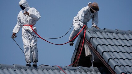 Professional painter on roof Working at heights is dangerous.