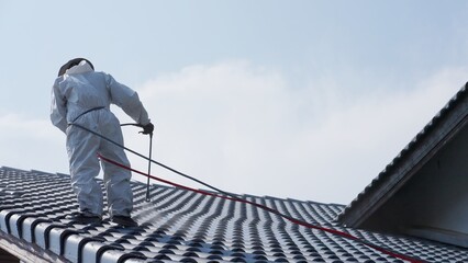 Professional painter on roof Working at heights is dangerous.
