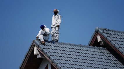 Professional painter on roof Working at heights is dangerous.