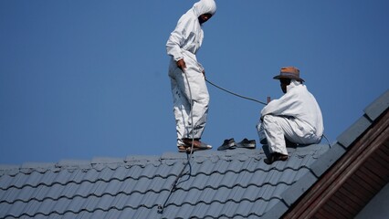 Professional painter on roof Working at heights is dangerous.