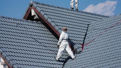 Professional painter on roof Working at heights is dangerous.