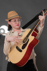 Playful woman guitarist strumming classical six string acoustic guitar