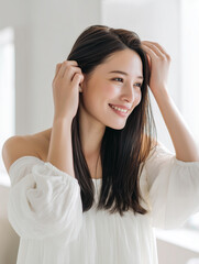 Fototapeta premium 前髪やこめかみをかきあげるロングヘアの女性