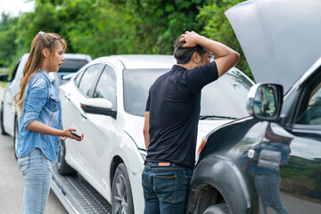asian man woman checking car engine after having accident. male and female asian person looking at motor after vehicle collision. asian woman and man examining car engine broke from car crash on road
