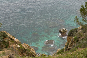 Coastal Cliff Overlooking Turquoise Waters With Rocky Formations During a Cloudy Day