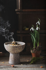 Incense burning on glowing coal - holy smoke ritual with different resins and herbs on a dark...