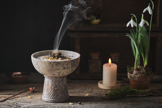 Incense burning on glowing coal - holy smoke ritual with different resins and herbs on a dark wooden rustic table. Wheel of the year festival imbolc, well-being and spiritual concept.