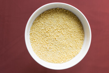 Yellow garri in a white bowl, top view of nigerian garri in a ceramic bowl, fried cassava, garri for eba